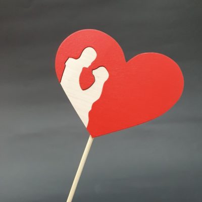 Czerwone serce na piku z parą z surowego drewna